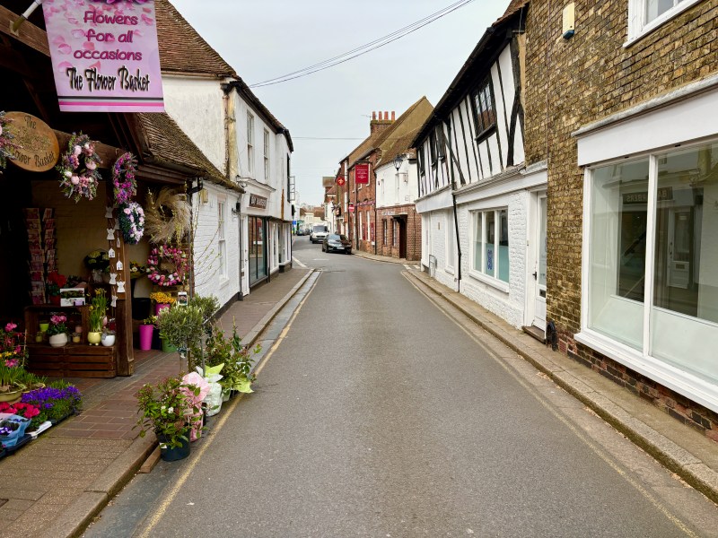 A narrow street in Sandwich featuring houses and shops